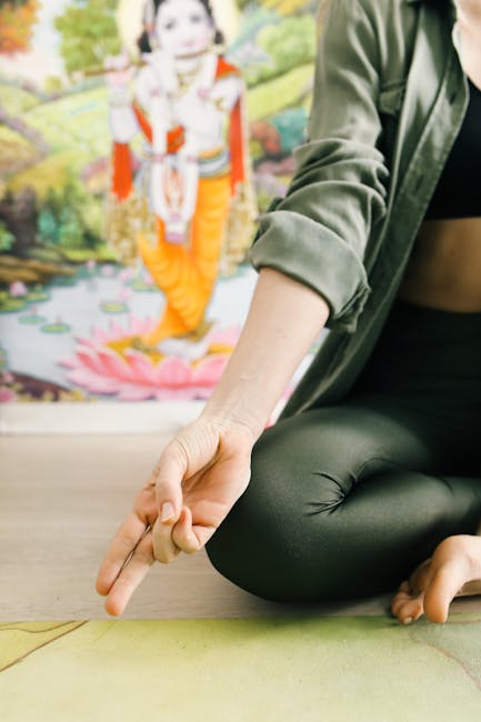Woman sitting in a lotus pose practicing a calming breathing technique in a serene, bright space.
